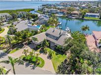 Stunning aerial view of a waterfront property with lush landscaping, pool, boat dock, and city views at 520 Harbor Cay Dr, Longboat Key, FL 34228
