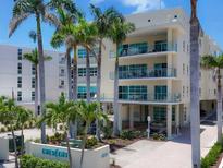 A beautiful condominium building with lush tropical landscaping and inviting facade at 6512 Midnight Pass Rd # 504, Sarasota, FL 34242