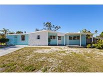 Charming single-story home with a light blue facade, white stone accents, and a covered front porch at 6520 Clemson St, Bradenton, FL 34207
