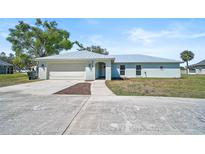 Inviting single-story home featuring a light blue exterior, metal roof, and spacious front yard at 7523 S Leewynn Dr, Sarasota, FL 34240