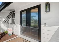 Beautiful modern front door with sidelight and modern exterior lighting at 7701 Palm Dr, Holmes Beach, FL 34217