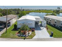 Charming home featuring lush landscaping and a covered carport, situated by a serene lake at 1416 41St E Ave, Ellenton, FL 34222