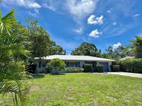 Charming single-story home with a well-manicured lawn, mature trees, and a metal roof, offering excellent curb appeal at 1507 30Th W St, Bradenton, FL 34205
