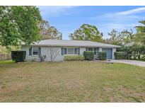 Charming one-story home boasts a well-manicured front lawn, complemented by mature landscaping and a gray metal roof at 1507 30Th W St, Bradenton, FL 34205