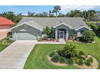 Charming single-story home featuring a well-manicured lawn and mature landscaping at 1878 Killdeer Ct, Venice, FL 34293