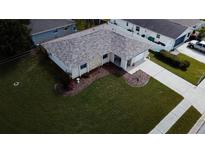 Aerial view of a well-maintained home featuring a lush lawn, new roof, and a charming front garden at 2412 15Th W St, Palmetto, FL 34221