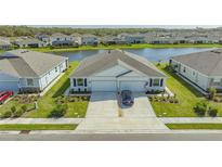Inviting paired home featuring a two-car garage, landscaped yard, and a serene water view at 427 157Th E Ct, Bradenton, FL 34212