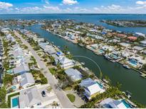 Stunning aerial view of waterfront property featuring lush landscaping, private dock, and canal access to the open bay at 511 68Th St, Holmes Beach, FL 34217