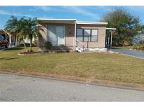 Charming single-story home with well-maintained lawn and mature palm trees, covered porch, and tidy landscaping at 5235 Cherry Hill Ave, Sarasota, FL 34234