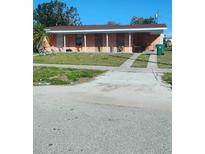 Charming single-story home with a spacious front yard and covered porch at 645 Dalton Blvd, Port Charlotte, FL 33952