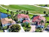 Stunning aerial view of the home situated on a golf course with lush landscaping and mature trees at 8025 Via Fiore, Sarasota, FL 34238