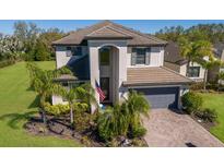 Beautiful two-story home featuring a well-manicured lawn and tropical landscaping in a sunny neighborhood at 10905 Copperlefe Dr, Bradenton, FL 34212