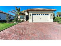 Beautiful single-story home with a brick driveway, well-kept lawn, and a beige exterior color at 2322 5Th E St, Palmetto, FL 34221
