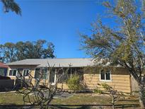 Cozy single story home featuring a well-kept yard with mature trees and tan siding at 303 60Th W Ave, Bradenton, FL 34207