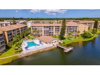 Stunning aerial view of condo complex with pool and dock on lake at 3525 Lake Bayshore Dr # 103J, Bradenton, FL 34205