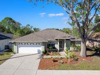 Charming single-story home featuring a well-manicured lawn, a two-car garage, and a welcoming front entrance at 4627 Breezy Pines Blvd, Sarasota, FL 34232