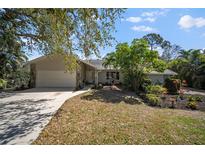 Charming single-story home features a lush front yard, stone accents, and a two-car garage at 4711 Placid Cir, Sarasota, FL 34231