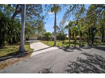 Beautiful single-story home with a long driveway and lush tropical landscaping at 4711 Placid Cir, Sarasota, FL 34231