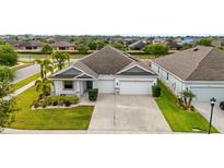 Beautiful single-story home featuring a well-manicured lawn and a spacious two-car garage at 5085 Ivory Stone Dr, Wimauma, FL 33598