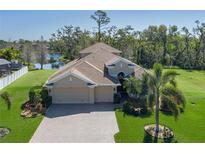 Stunning single-Gathering home featuring a large 3 car garage, brick driveway, lush landscaping, and tranquil waterfront views at 5412 72Nd E Ter, Ellenton, FL 34222