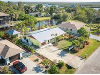 Aerial view of a charming property with defined borders, featuring mature landscaping and water access at 9031 Hilolo Ln, Venice, FL 34293
