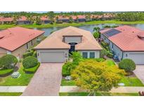 Beautiful single-Gathering home with lush landscaping and a paver driveway, located near a scenic lake at 1290 Cielo Ct, North Venice, FL 34275
