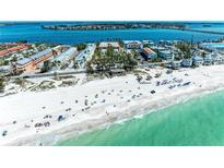 Beautiful aerial view of the beach with white sand, blue water, and nearby condos and townhomes at 1325 Gulf Dr N # 248, Bradenton Beach, FL 34217