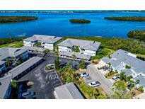 Stunning aerial view of waterfront condos, lush landscaping, and serene blue waters at 1389 Perico Point Cir # 140, Bradenton, FL 34209