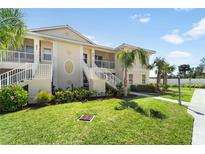 Two-story condo with well-kept lawn and landscaping and a shared stairwell to the units at 200 Gardens Edge Dr # 222, Venice, FL 34285