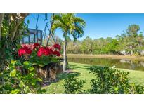 A beautifully landscaped backyard with a pond view and vibrant red hanging flowers adds charm to the outdoor space at 315 Londonderry Dr, Sarasota, FL 34240