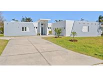 Modern, gray and white home featuring a concrete driveway and minimalist landscaping at 3319 Mayflower St, Sarasota, FL 34231