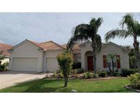 Charming single-story home featuring a well-manicured lawn, mature palm trees, and a terracotta tile roof at 4506 62Nd E Ter, Bradenton, FL 34203