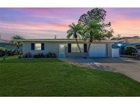 Charming single-story home with manicured lawn, beautiful trees, and attached garage showcasing a welcoming curb appeal at 4550 Ardale St, Sarasota, FL 34232