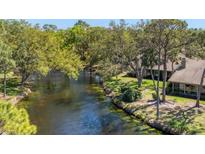 Picturesque backyard with a serene canal view surrounded by lush greenery at 5655 Pipers Waite # 27, Sarasota, FL 34235