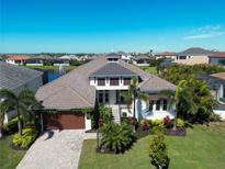 Beautiful home with a well manicured lawn, a brick driveway and tropical plants at 6208 Signature Pointe Ln, Bradenton, FL 34210