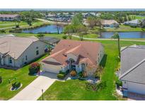 Stunning aerial view of home with tile roof, pond, and lush landscaping in a vibrant community at 6514 Stone River Rd, Bradenton, FL 34203