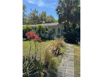 Charming single-story home with lush landscaping and a stone walkway, creating a welcoming curb appeal at 728 41St St St, Sarasota, FL 34234