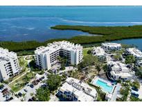 Stunning aerial view of the waterfront condo complex with lush landscaping and beautiful bay views at 1930 Harbourside Dr # 136, Longboat Key, FL 34228