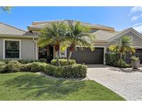 Inviting home showcasing well-maintained landscaping, a paver driveway, and a neutral color palette under a clear blue sky at 2512 61St E Ave, Ellenton, FL 34222