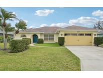 Charming single-story home featuring lush landscaping, a well-manicured lawn, and a colorful front door at 3419 31St E St, Bradenton, FL 34208