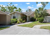 Home featuring manicured lawn, sidewalk, and shade trees at 3461 Tallywood Cir # 7067, Sarasota, FL 34237