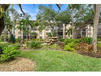 Lovely condo exterior featuring a fountain and landscaped garden with beautiful mature shade trees at 515 30Th Ave W # H410, Bradenton, FL 34205