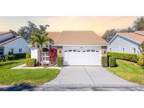 Charming home featuring a well-manicured lawn, tile roof, and an attached two-car garage at 5814 Garden Lakes Fern, Bradenton, FL 34203