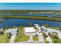 Waterfront home featuring a private dock, lush landscaping, and boat lift at 603 Ravenna N St, Nokomis, FL 34275