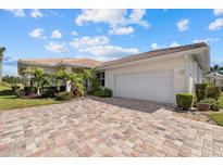 Charming single-story home boasts a brick driveway, manicured landscaping and an attached two-car garage at 6766 Greenview Ln, Englewood, FL 34224