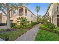 Charming multi-Gathering home with lush landscaping and a brick walkway leading to the entrance at 7959 Limestone Ln # 14-104, Sarasota, FL 34233