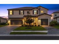 Charming two-story home with a well-manicured lawn, brick-paved driveway, and a two-car garage, enhancing curb appeal at 16455 Whale Grey Pl, Bradenton, FL 34211