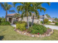 Charming single-story home boasts lush landscaping, mature palms, and a well-manicured lawn at 21037 Anclote Ct, Venice, FL 34293