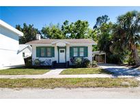 Charming single-story home with green shutters, a well-kept lawn, and mature trees at 2530 Loma Linda St, Sarasota, FL 34239