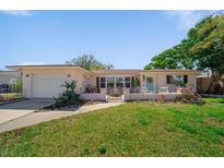 Charming single-story home boasts a well-manicured lawn, inviting porch, and lovely landscaping at 260 Hammock Ter, Venice, FL 34293